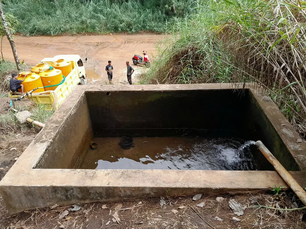 Sebuah truk mengambil air dari waduk di kaki bukit Tanjung Ueboelie, yang akan didistribusikan ke rumah-rumah warga di Pulau Gebe. Sumber air ini terancam karena berada di area pertambangan nikel PT Smart Marsindo.